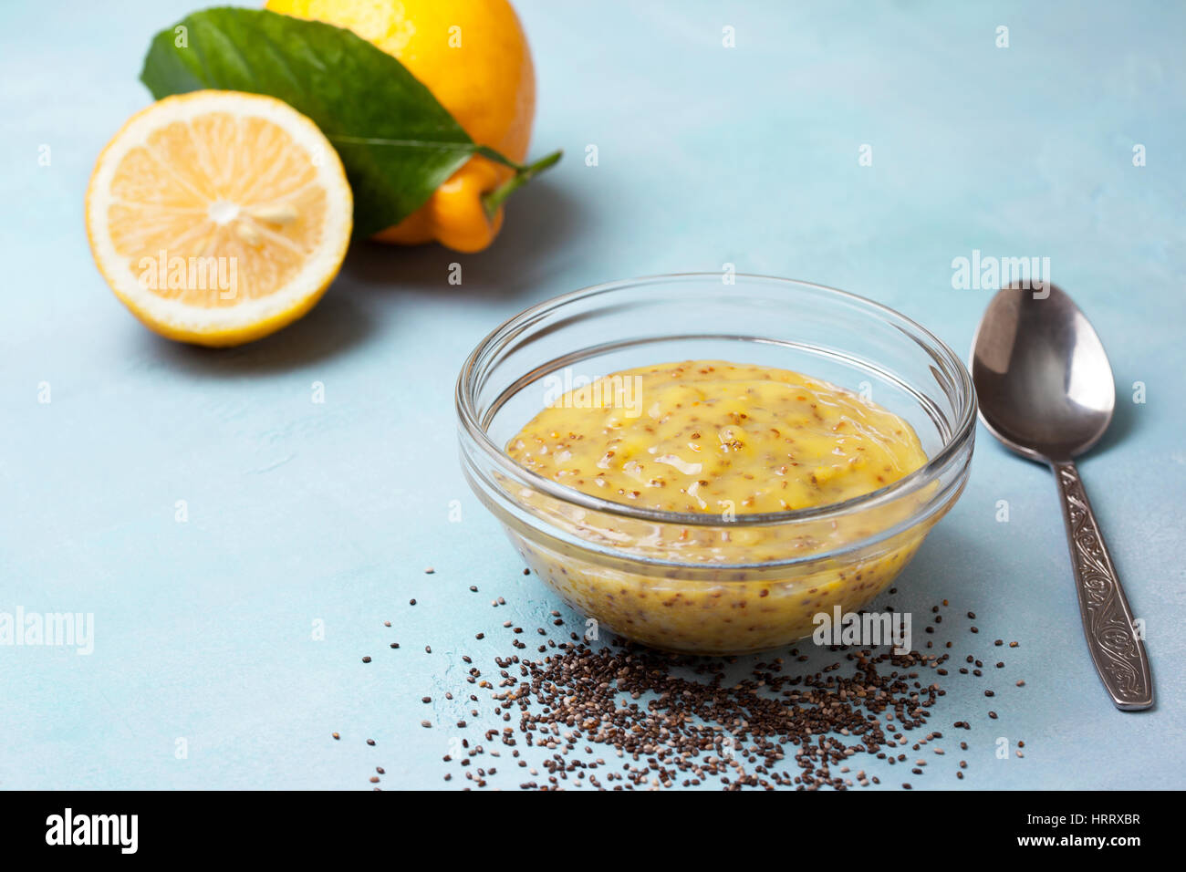 lemon curd chia pudding in a glass bowl,, fresh lemons on a blue background Stock Photo