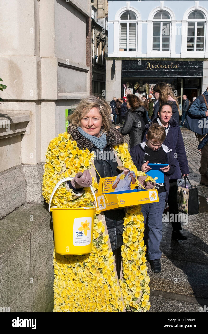 Marie Curie Charity Daffodil Appeal woman daffodils collecting donations street Truro Cornwall UK Stock Photo
