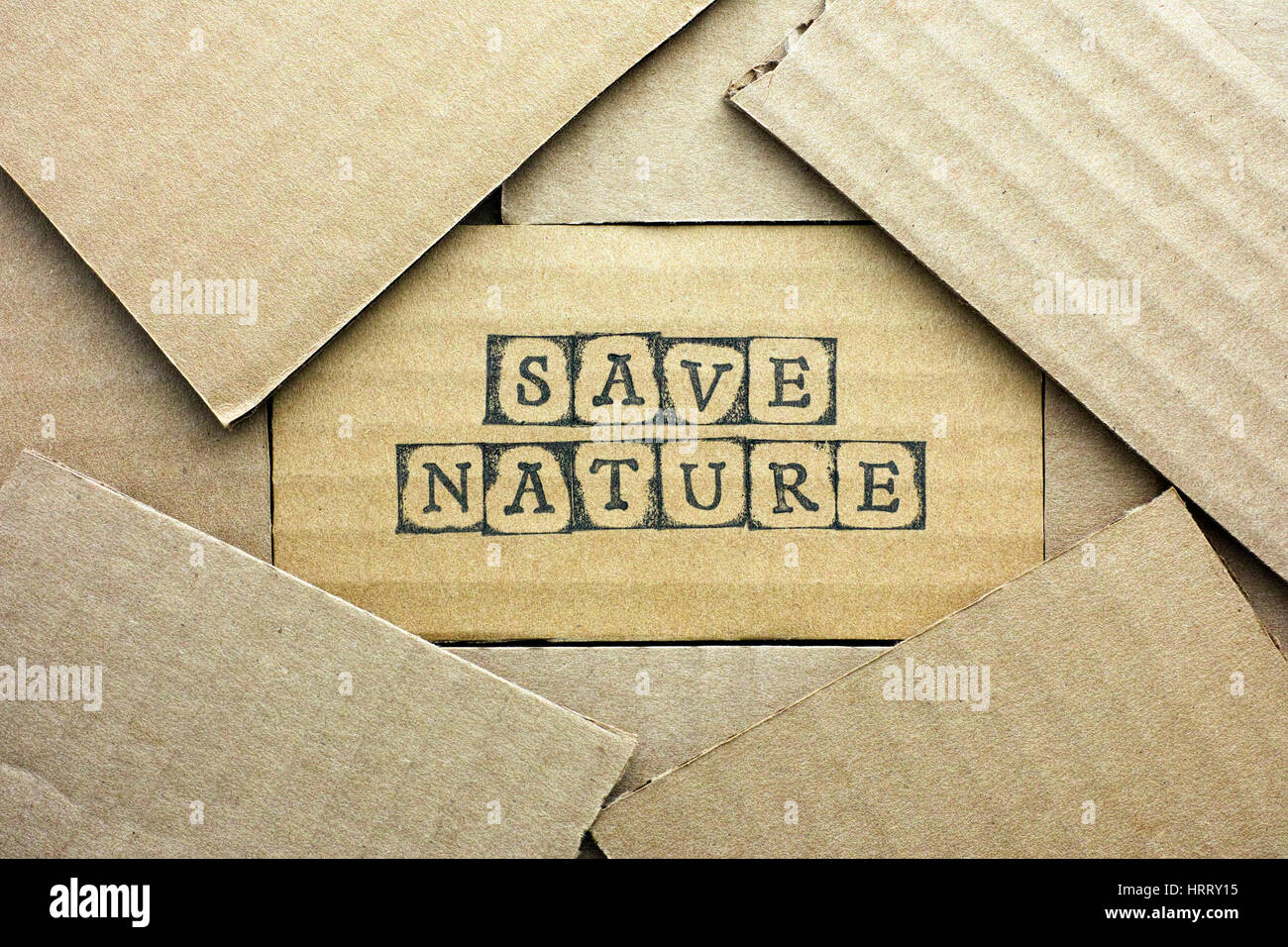 Cardboard card with words Save Nature made by black alphabet stamps