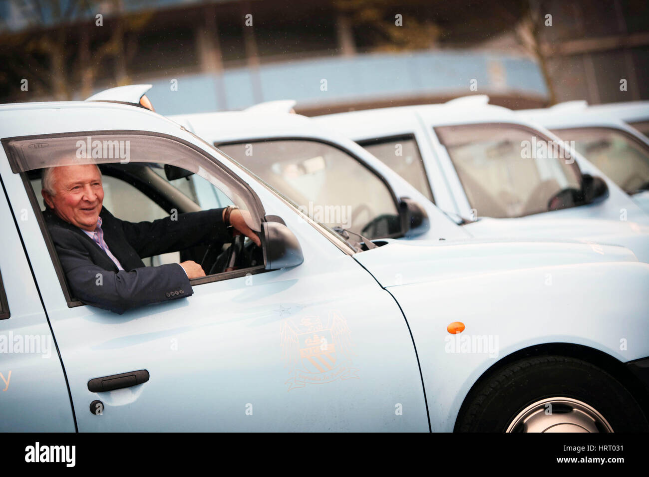 Mike Summerbee leads a fleet of special Manchester City FC branded taxis Stock Photo
