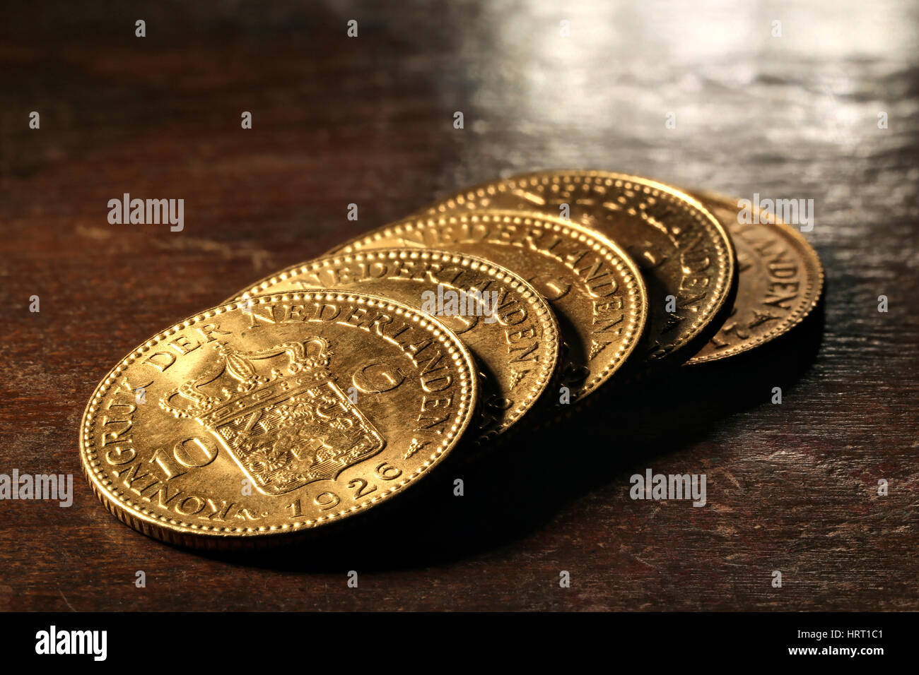 Dutch Wilhelmina gold coins on rustic wooden background Stock Photo