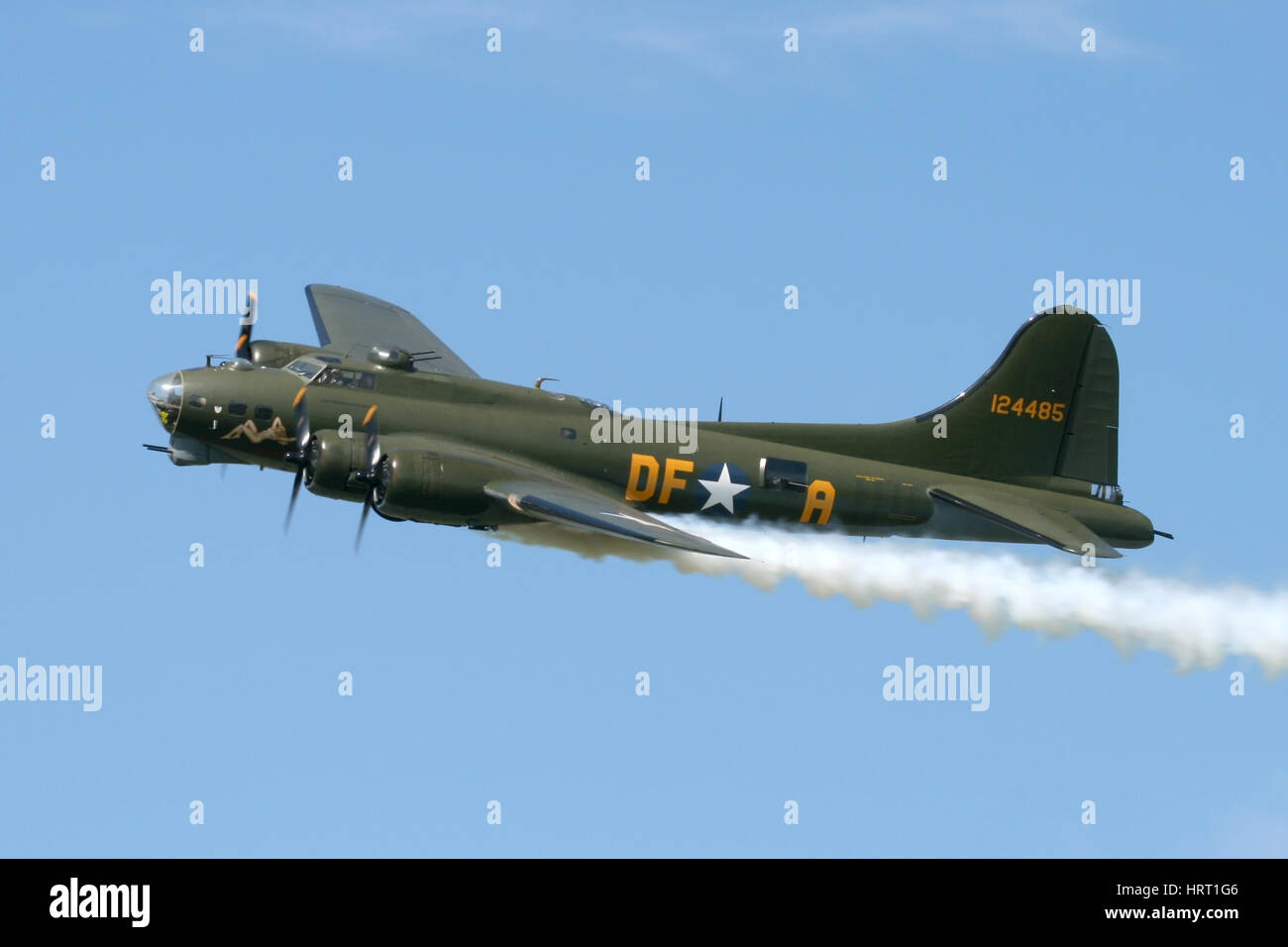 The UK's, and now also Europe's only airworthy B-17 with a flypast at a Rougham Airshow in Suffolk. The smoke is simulated battle damage. Stock Photo