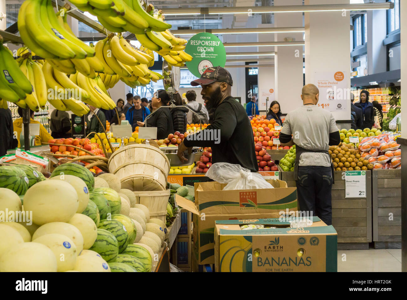 A worker stocks bananas and other fruit in the produce department in the new Whole Foods Market in Newark, NJ on opening day Wednesday, March 1, 2017. The store is the chain's 17th store to open in New Jersey. The 29,000 square foot store located in the redeveloped former Hahne & Co. department store building is seen as a harbinger of the revitalization of Newark which never fully recovered from the riots in the 1960's.  (© Richard B. Levine) Stock Photo