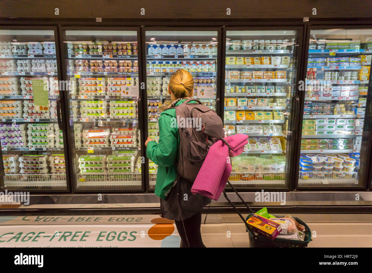 A shopper chooses cafe-free eggs in a cooler in the new Whole Foods Market in Newark, NJ on opening day Wednesday, March 1, 2017. The store is the chain's 17th store to open in New Jersey. The 29,000 square foot store located in the redeveloped former Hahne & Co. department store building is seen as a harbinger of the revitalization of Newark which never fully recovered from the riots in the 1960's.  (© Richard B. Levine) Stock Photo