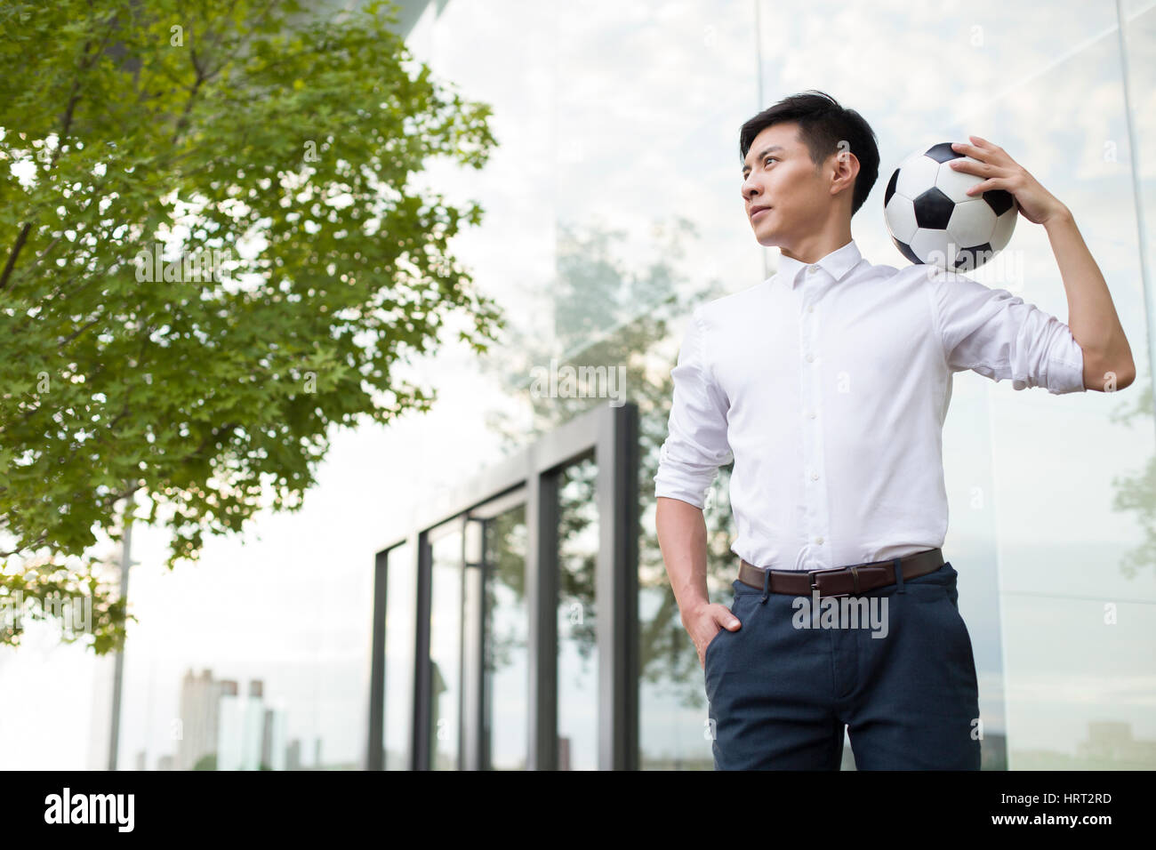 Young businessman holding a soccer ball Stock Photo - Alamy