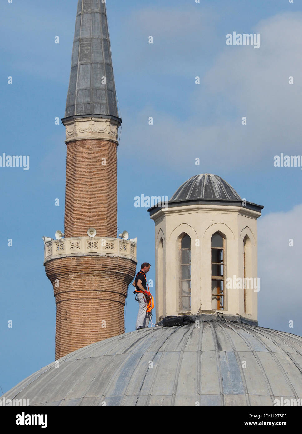 MAINTENANCE WORKER ON DOMED ROOF WITH SAFETY HARNESS NO HELMET SULTANAHMET AREA  NEAR HAGIA SOPHIA ISTANBUL TURKEY Stock Photo