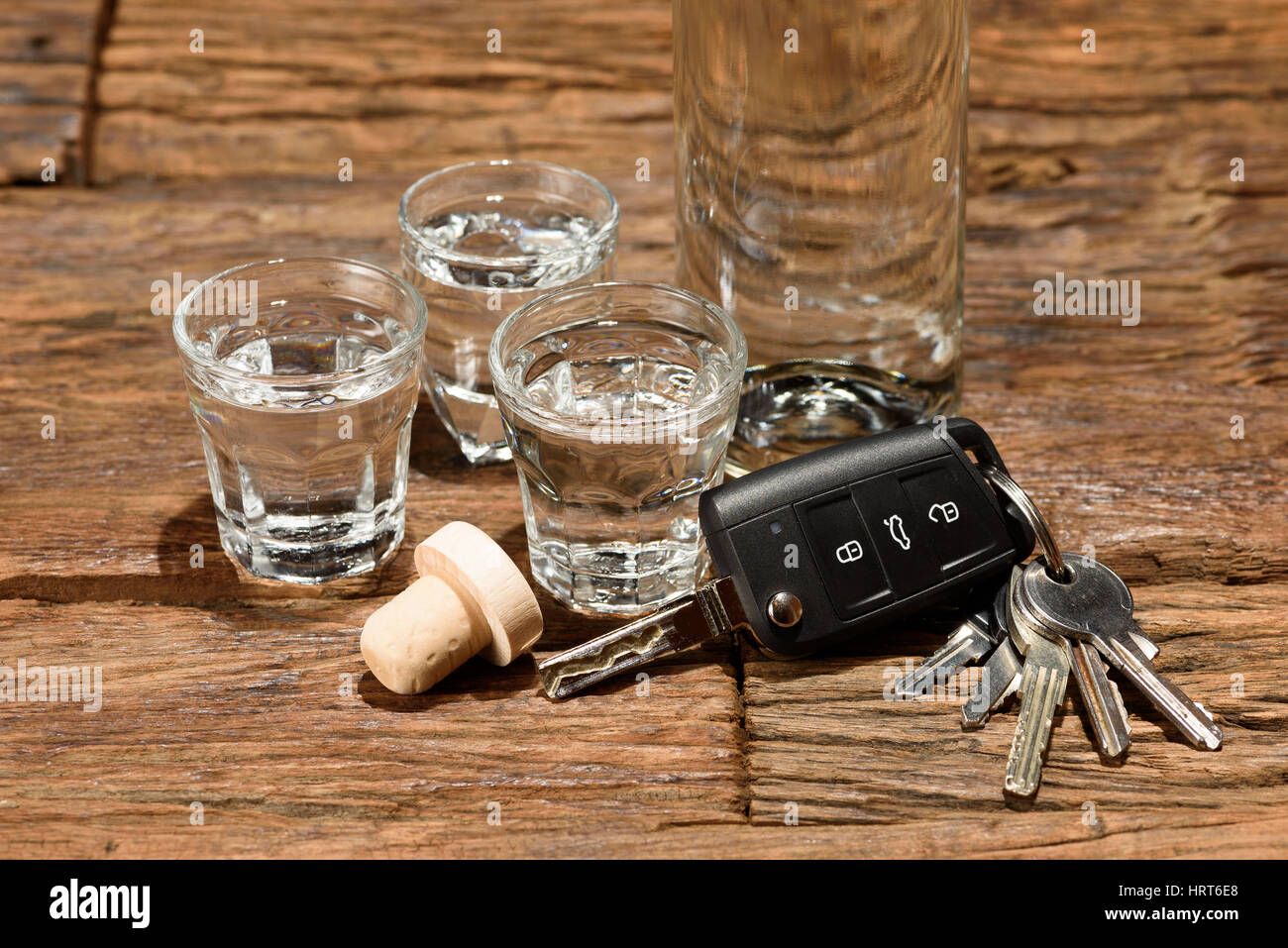 Shot glasses and a car key on an old wooden table. Don't drink and drive. Stock Photo