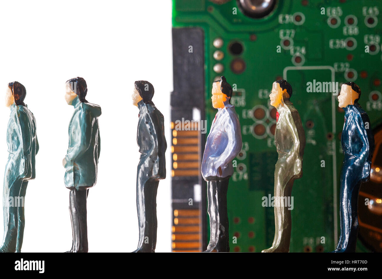 Miniature figurines of line of men standing in front of computer hard ...