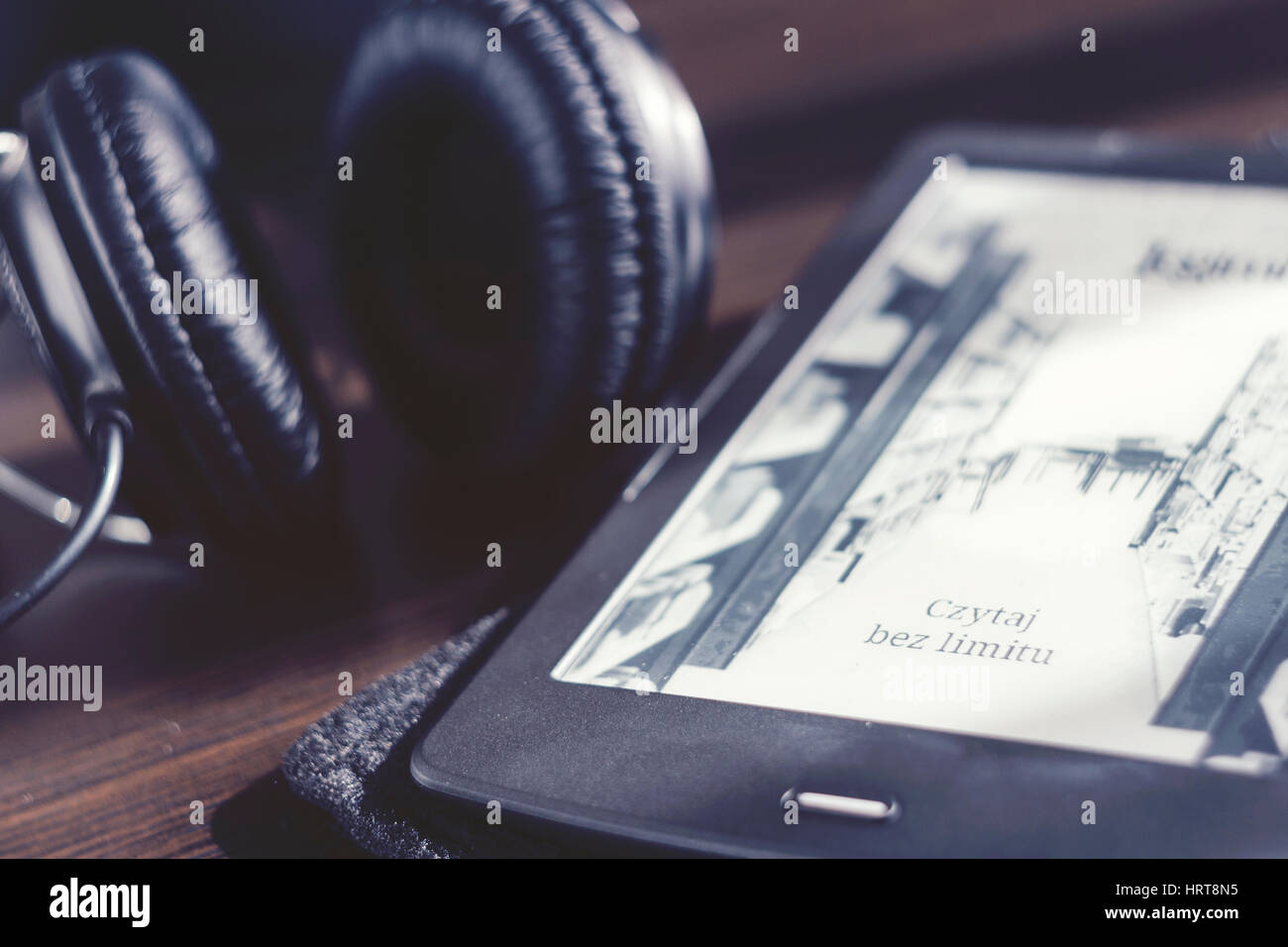 Pair of headphones and open ebook reader on the desk Stock Photo