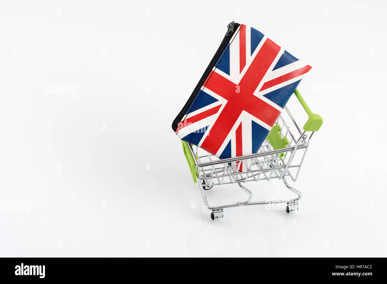 Union Jack coin purse / wallet in toy shopping trolley. Metaphor UK consumer spending, economy & retail/high street sales, cost of living, low income. Stock Photo