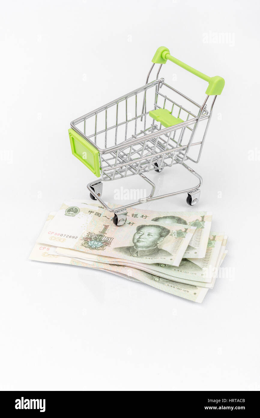 Shopping trolley / cart over several Chinese 1 Yuan banknotes. Metaphor for Chinese economy, consumer spending, economy. Stock Photo