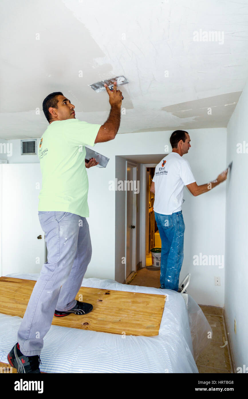 Miami Beach Florida,home improvement,remodeling,contractor,plastering,ceiling,Hispanic man men male,worker,tool,trowel,spreading,FL170112014 Stock Photo