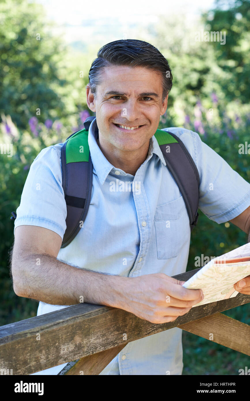 Portrait Of Mature Man Hiking In Countryside With Map Stock Photo
