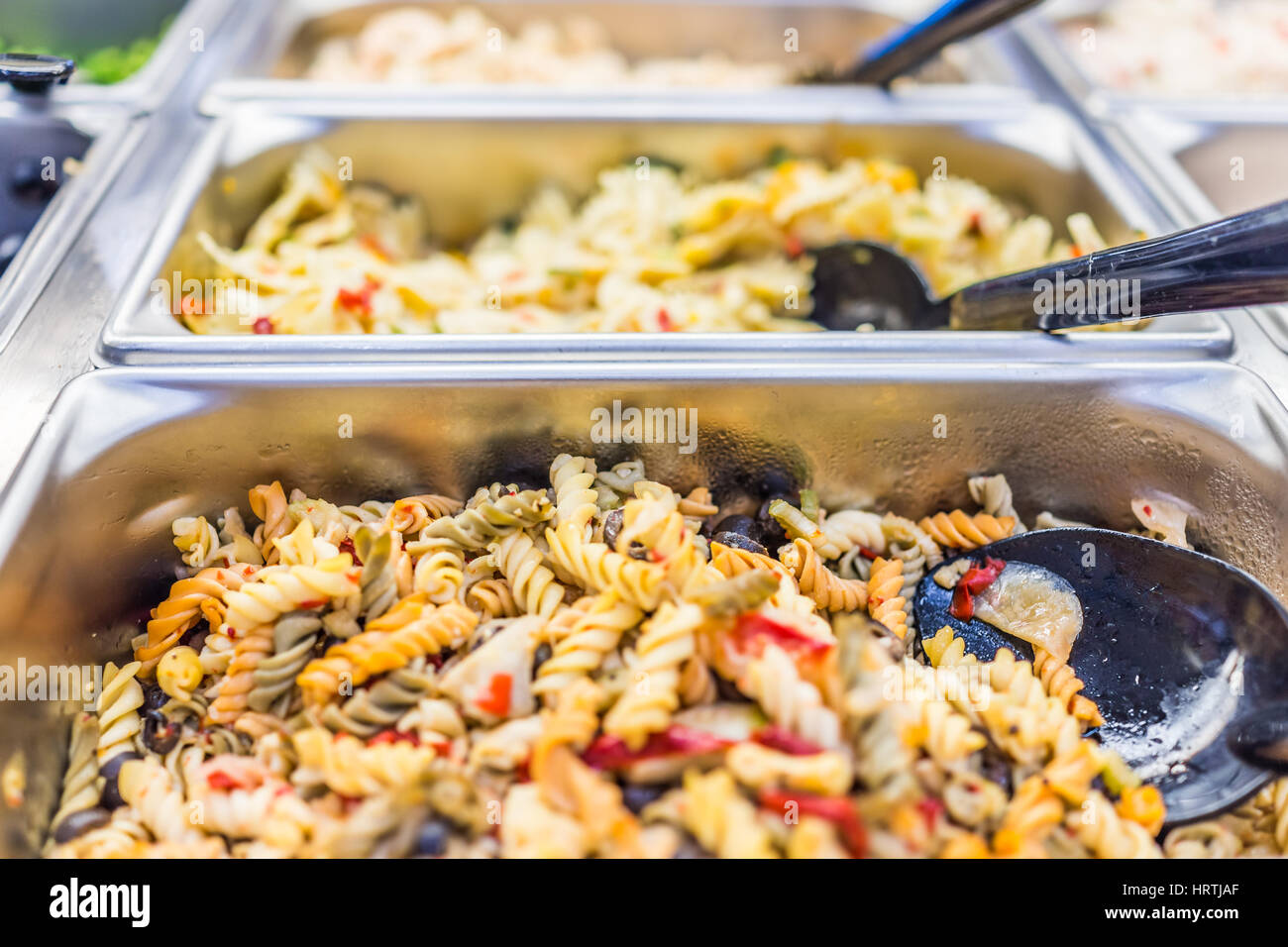 Macro closeup of different pasta salads in salad bar counter Stock Photo