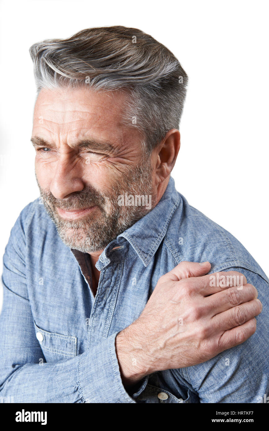 Studio Shot Of Man Suffering With Frozen Shoulder Stock Photo