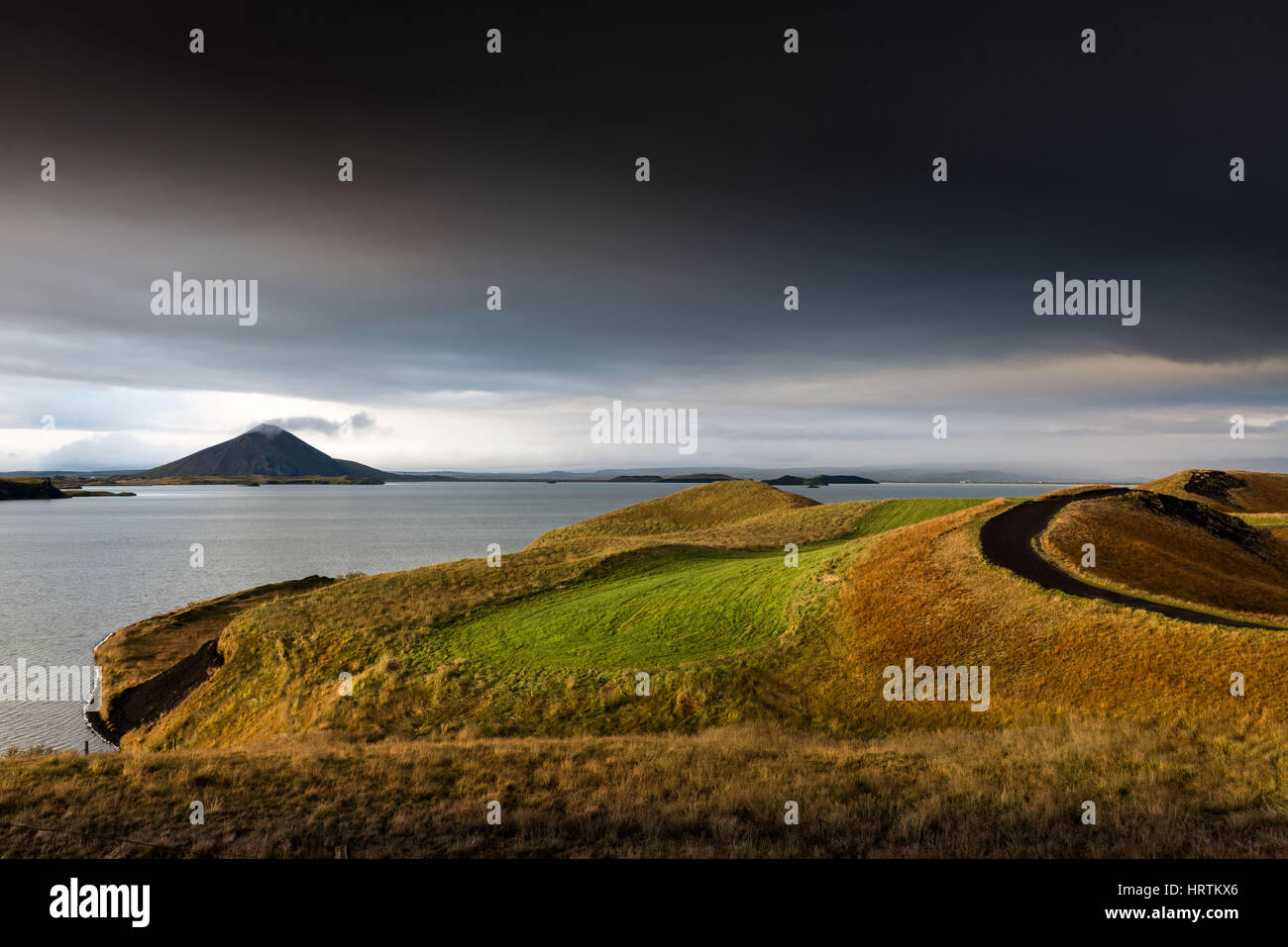 Myvatn, Iceland - The Vindbelgjarfjall volcano lets off steam on the horizon near Lake Myvatn at dusk Stock Photo