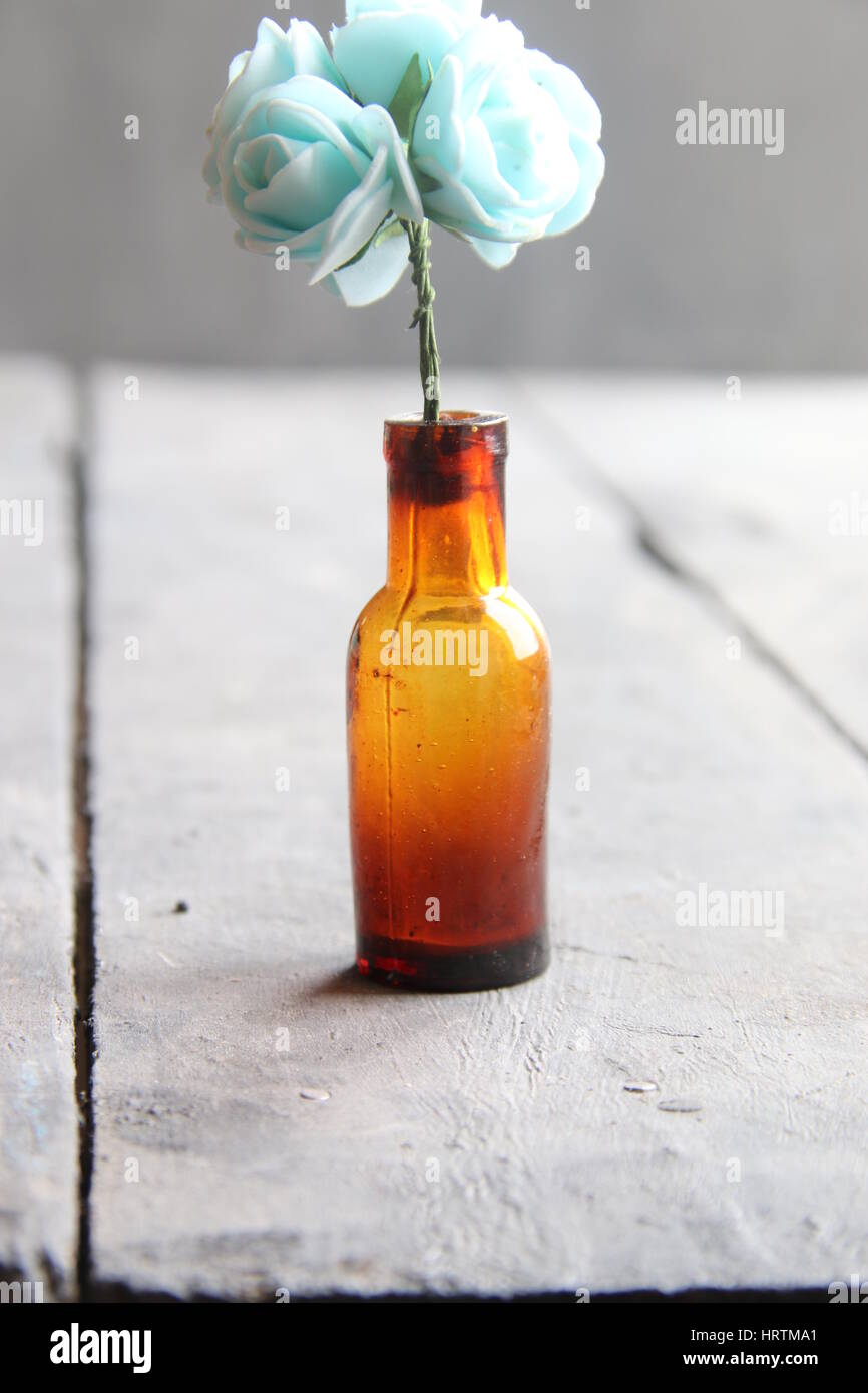 flowers in a bottle on old vintage table Stock Photo