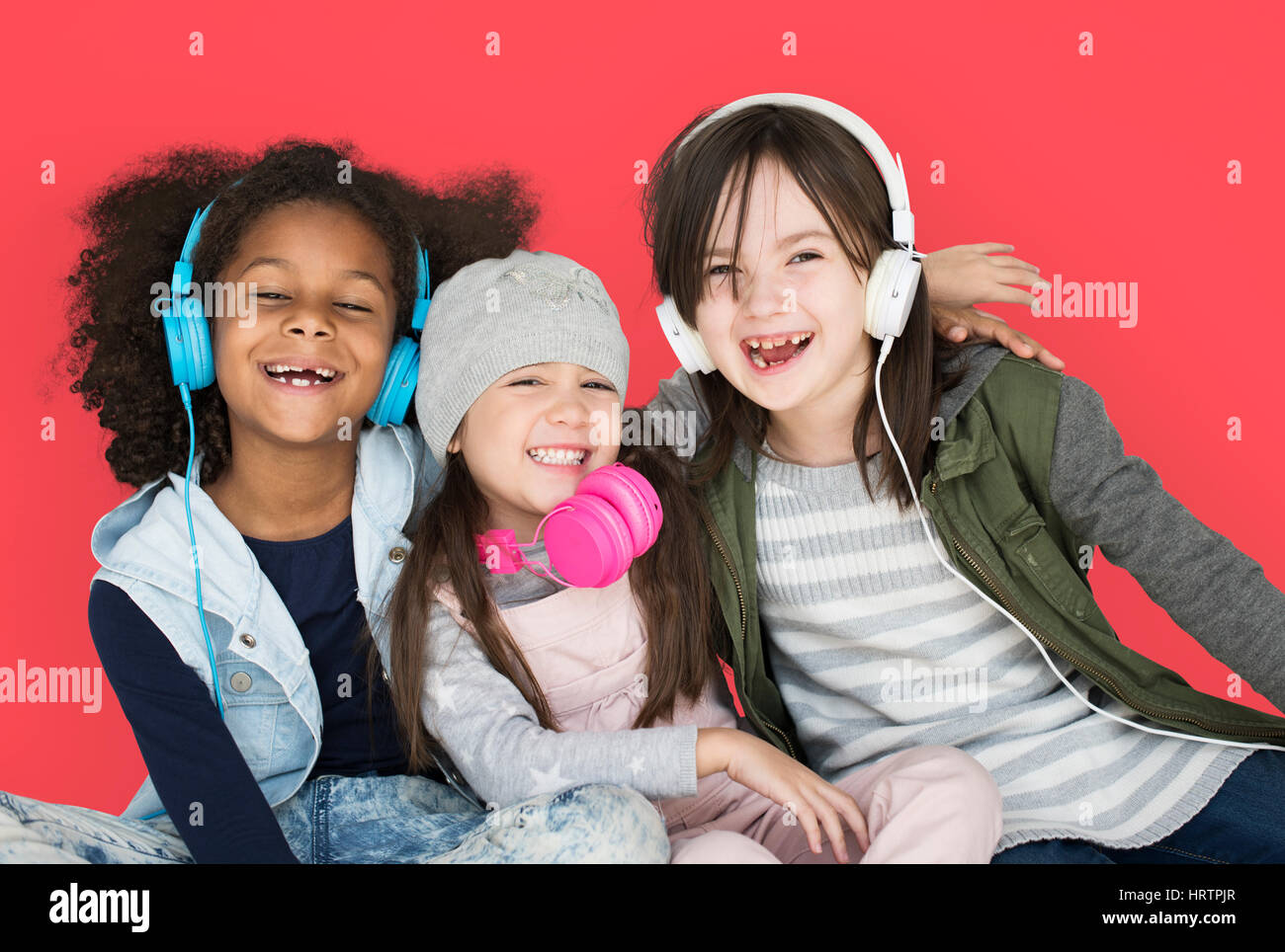 Group of Little Girls Studio Smiling Wearing Headphones and Winter Clothes Stock Photo