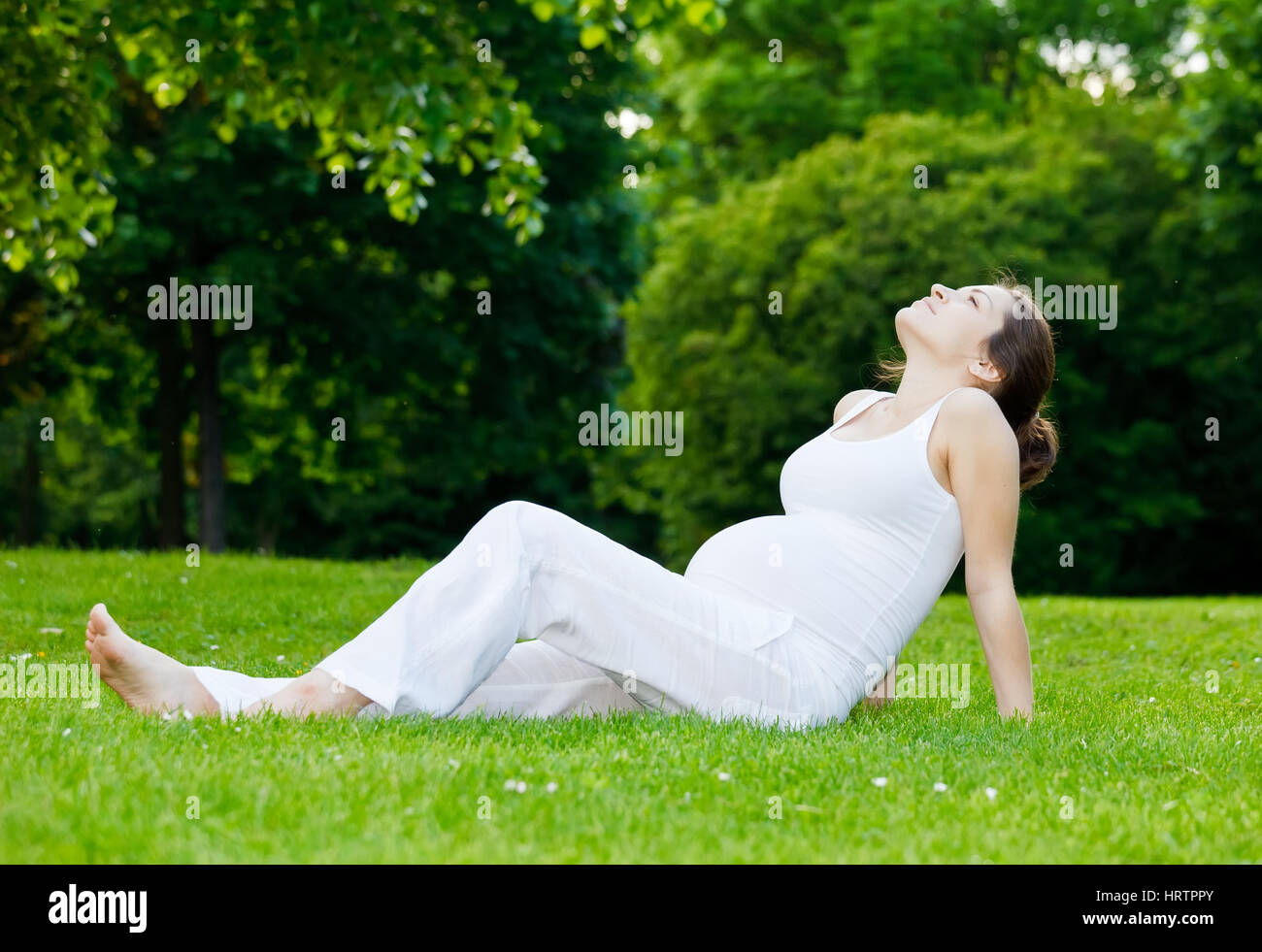 Beautiful pregnant woman relaxing in the park Stock Photo - Alamy