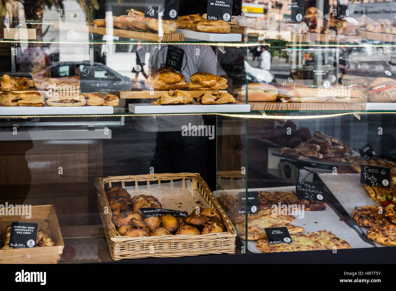 Bakery and pastry shop display window with variety of breads, pies