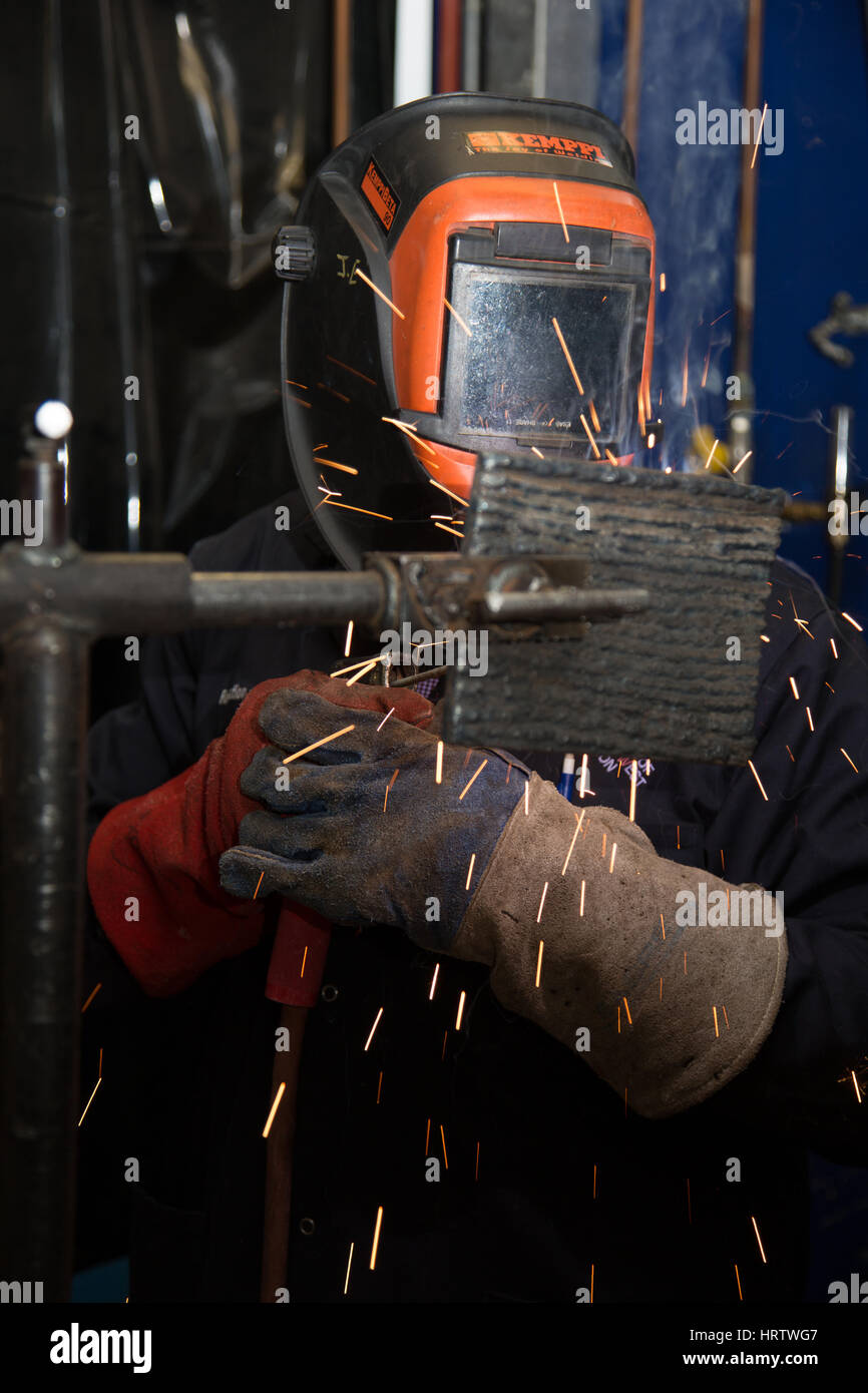 A welder at work using a protective mask Stock Photo