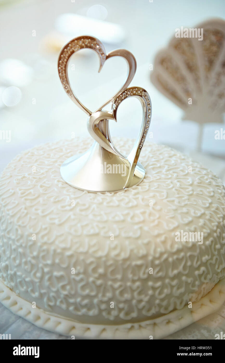 Closeup of wedding cake with two hearts decoration. Beautiful wedding sweet cake Stock Photo