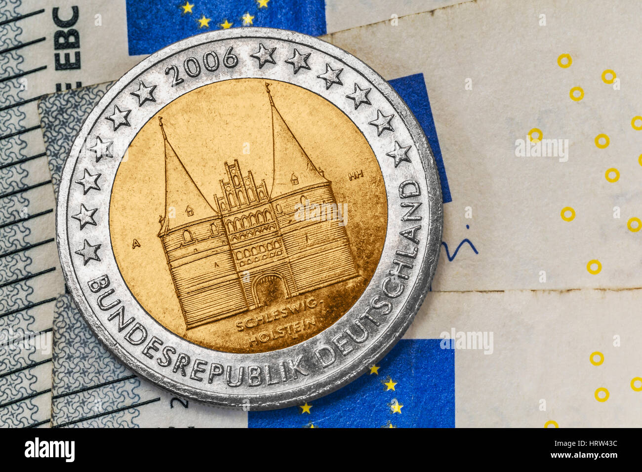 a 2 euro commemorative coin from Germany with the Holsten Gate Luebeck on euro banknotes Stock Photo