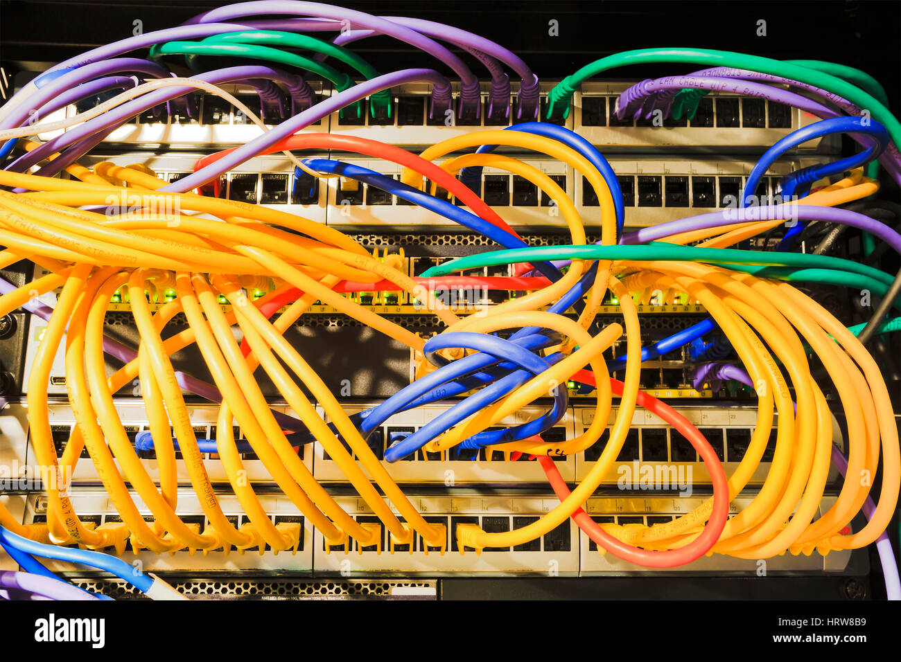 Patch panels, sockets, patch cables connected to the network equipment inside the rack of Data Centre. Stock Photo