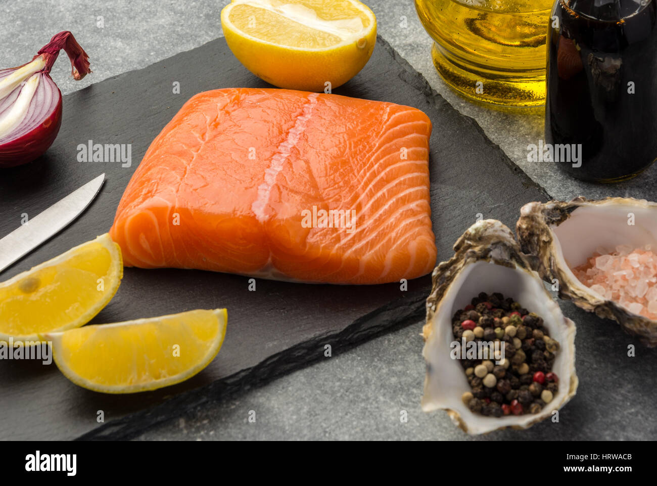 Ingredients for tartare sauce from a salmon, rich in omega 3 oil, with aromatic herbs and spices with a lemon, tomato, garlic on black background. Hea Stock Photo