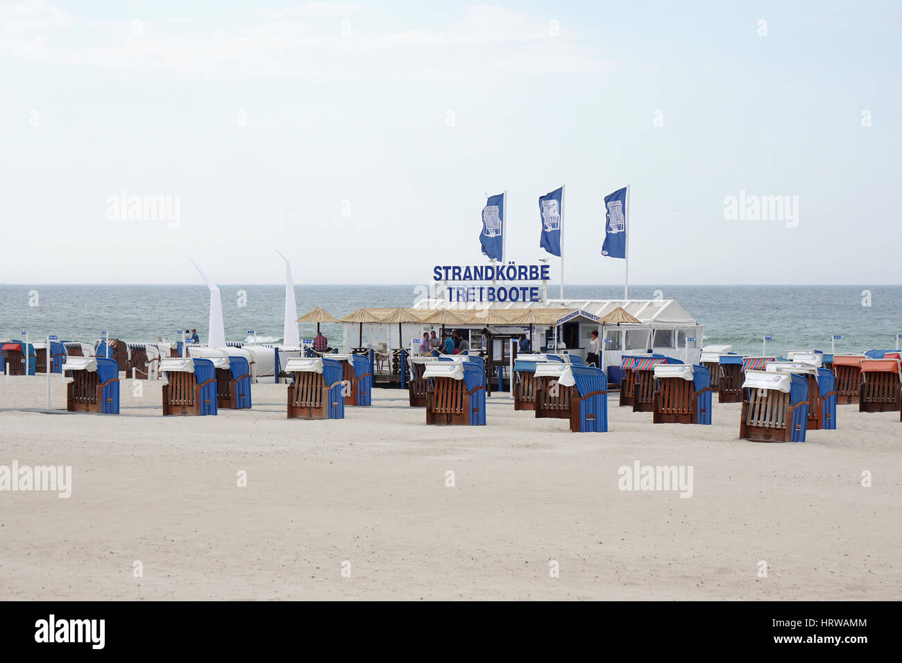 Rostock, Germany - May 30th, 2016: Beach bar with roofed wicker beach chair, known as Strandkorb in Germany, rental on a preseason day at Warnemunde s Stock Photo