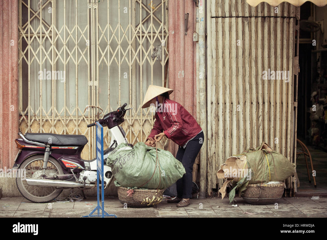 Hanoi, Vietnam - 3 MARCH: Women packing baskets with cardboard on the street of Hanoi, March 3, 2014. Stock Photo