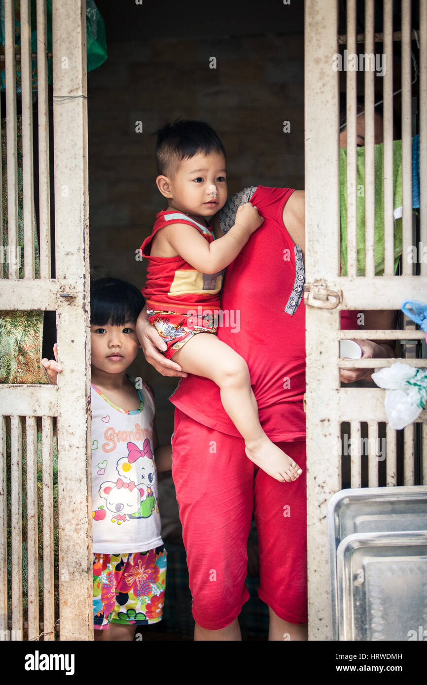 Hanoi, Vietnam - April 26, 2014: Portrait of  Vietnamese family at the entrance of their home on the street of Hanoi, Vietnam on April 26, 2014. Stock Photo