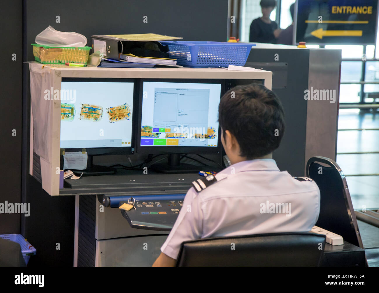 Checking luggage at the airport. A policeman watches a monitor baggage