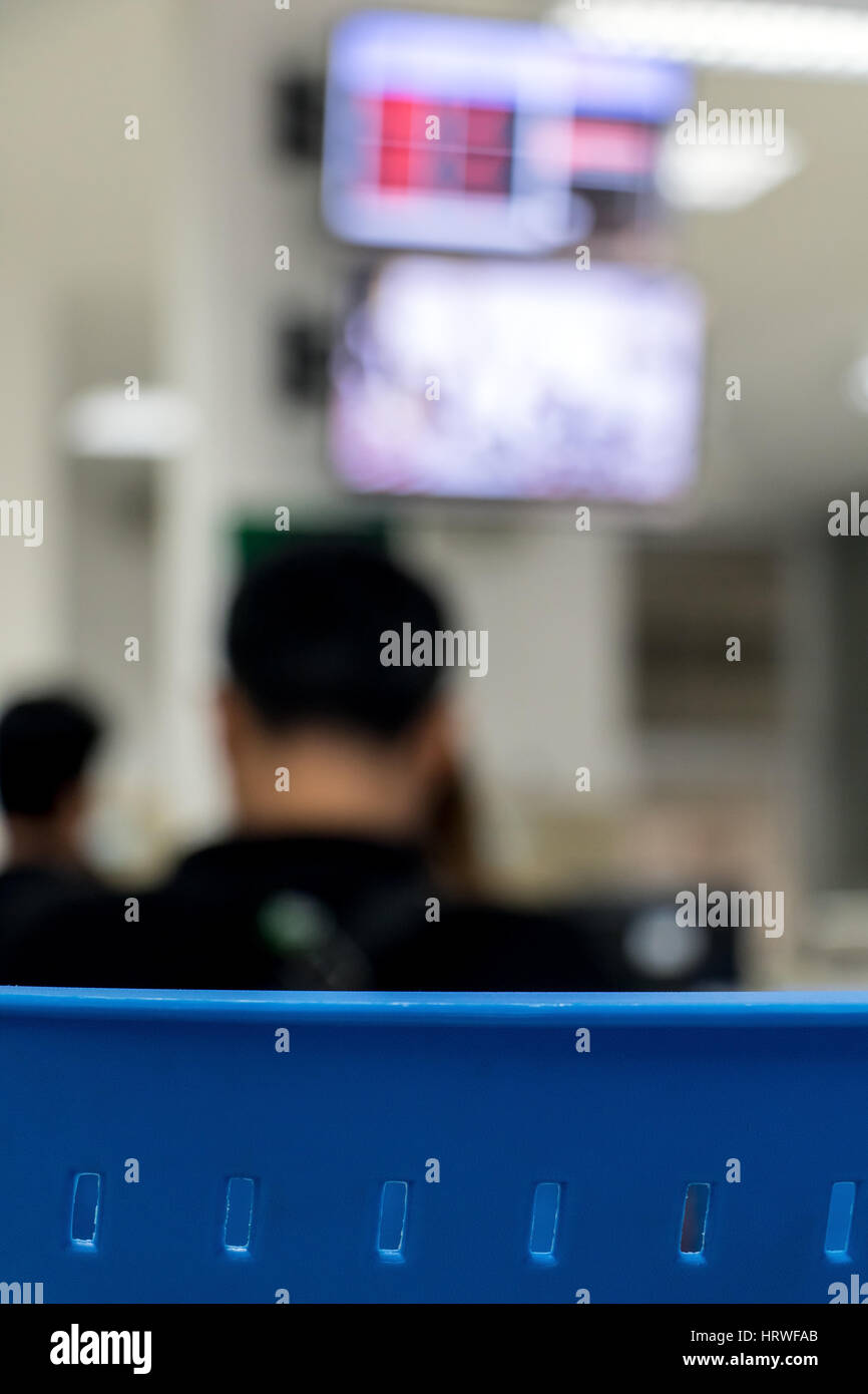 A chair with a blurred background office. People sit below the display with counter of queue. Stock Photo