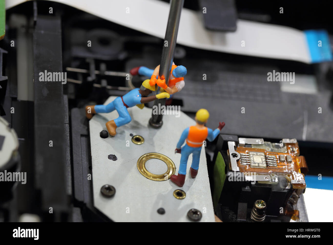 Selective focus of miniature engineer and worker fixed to remove screw by screwdriver for repair cd rom of computer and use for business background. Stock Photo