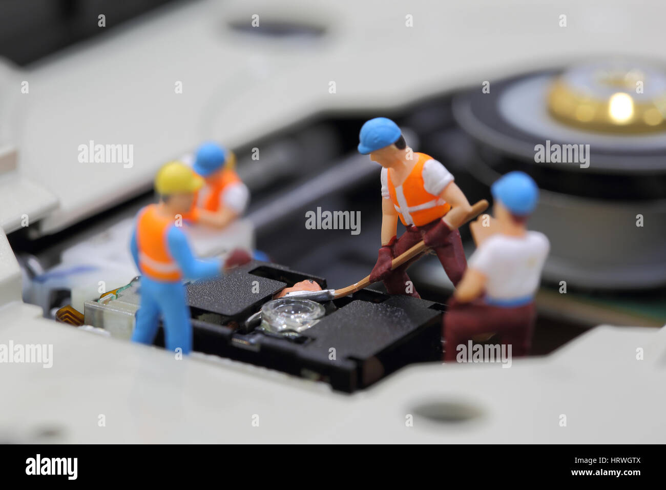 Selective focus of miniature engineer and worker fixed to clean CD rom reader of mainboard computer and use for business background. Stock Photo