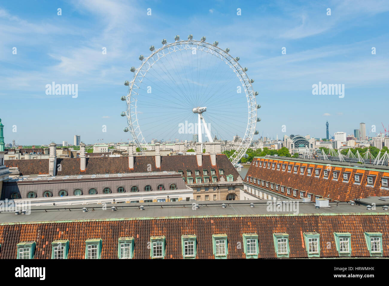 The London Eye with the roof tops of the old county hall in the
