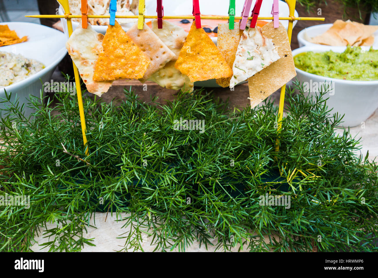 Creative food styling of nachos and flat bread hung using colored clips Stock Photo