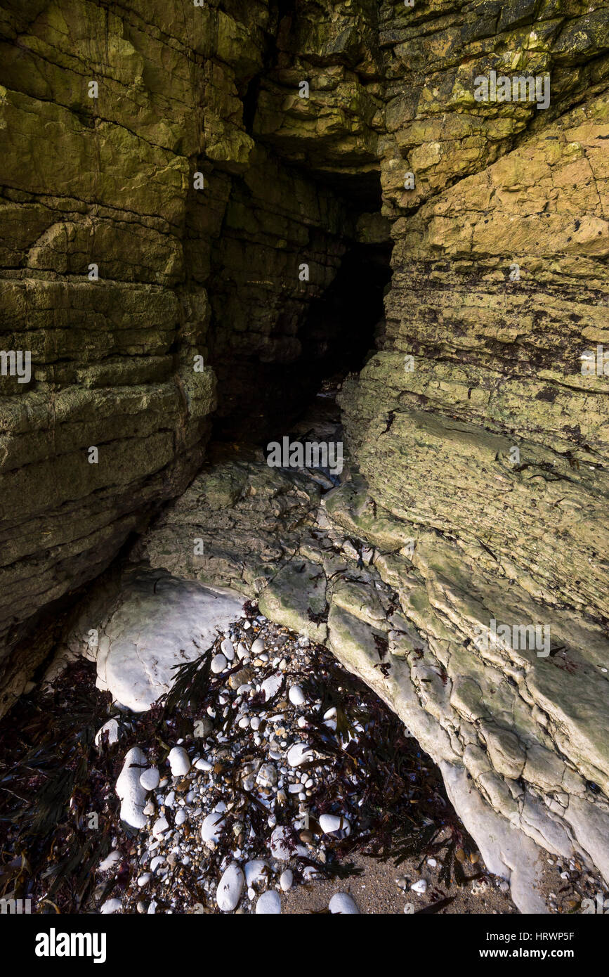 Looking into a rocky cave in the cliffs at Selwicks bay, Flamborough, North Yorkshire, England. Stock Photo