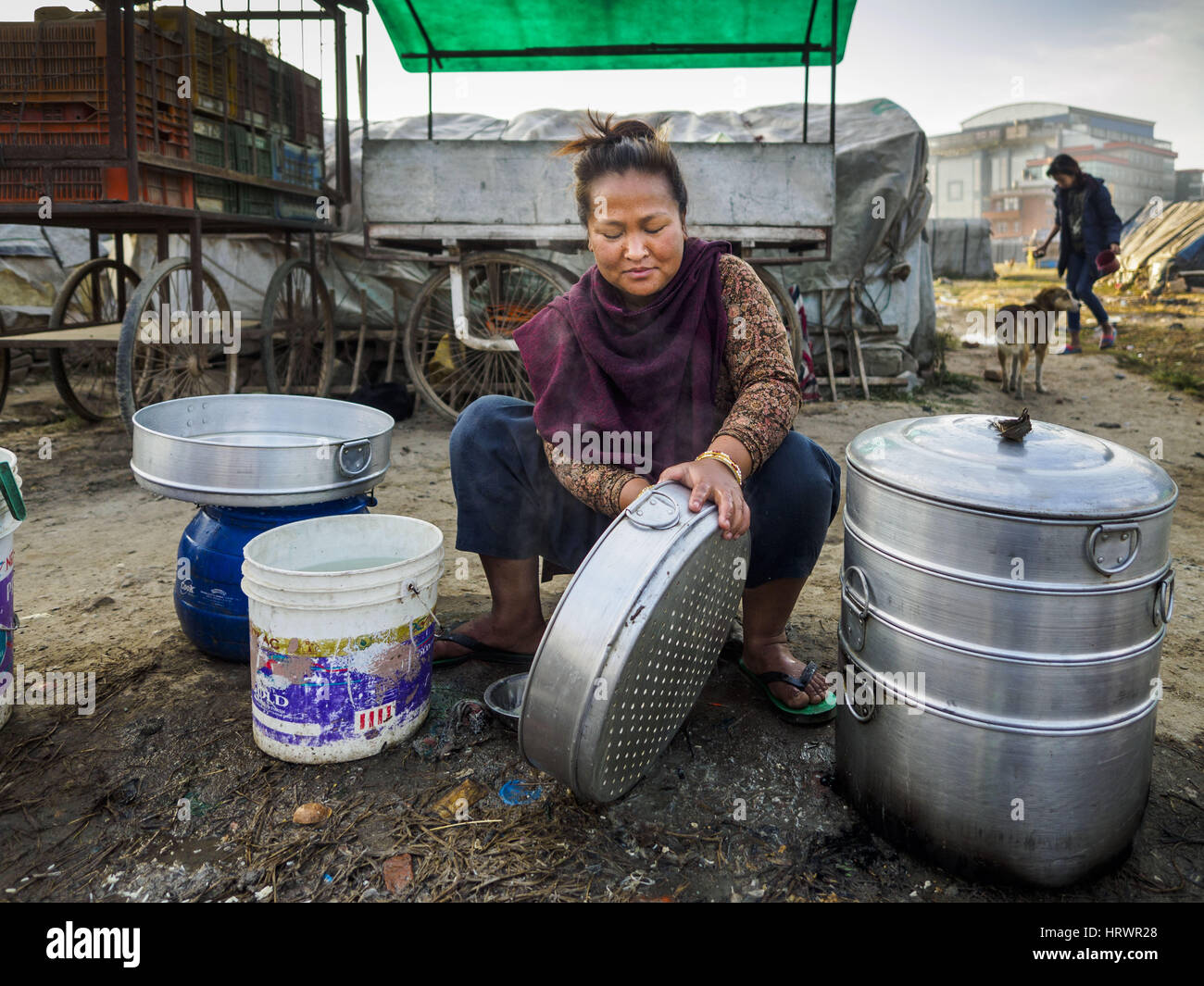 Kathmandu, Central Development Region, Nepal. 4th Mar, 2017. A woman from rural Nepal cleans the pans she uses to make steamed momos (a type of Nepalese dumpling) in an IDP camp in the center of Kathmandu. She lives in the camp with her husband and son and sells momos on the streets of Kathmandu. The camp opened days after the April 2015 earthquake devastated Nepal, killing almost 9,000 people. At its peak, about 1,800 families lived in the camp. The camp is still open nearly two years after the earthquake, about 400 families currently live in the camp. Camp residents say the Kathmandu munic Stock Photo