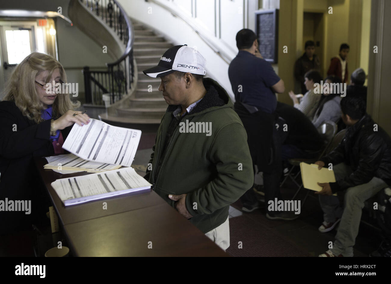 Plainfield, Plainfield, USA. 4th Mar, 2017. FLOR GONZALEZ, left, helps get Santos Garcia, an undocumented immigrant get his identification card at City Hall of Plainfield, New Jersey. The City of Plainfield proclaimed a resolution designating the city as a fair and welcoming community. The City's Clerk office registered nearly 800 undocumented immigrants have been registered with the program since last February, 'officials said. Credit: Brian Branch Price/ZUMA Wire/Alamy Live News Stock Photo
