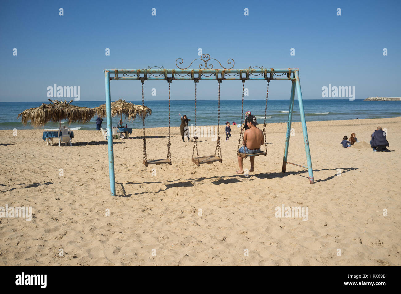 Beirut,Lebanon. 5th March 2017. A man relaxes on a swing at the beach