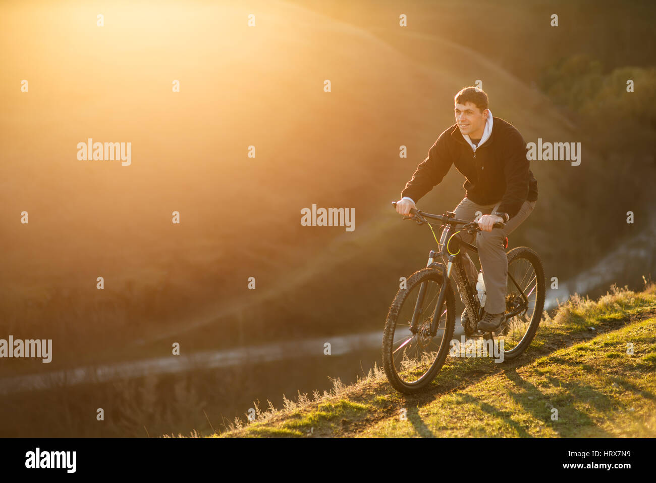 Cyclist riding on the top of a hill and watching the view. Cyclist in ...