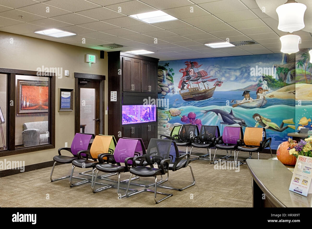 The waiting area of a modern pediatrician's office, decorated in a marine theme with an aquarium and murals. Stock Photo