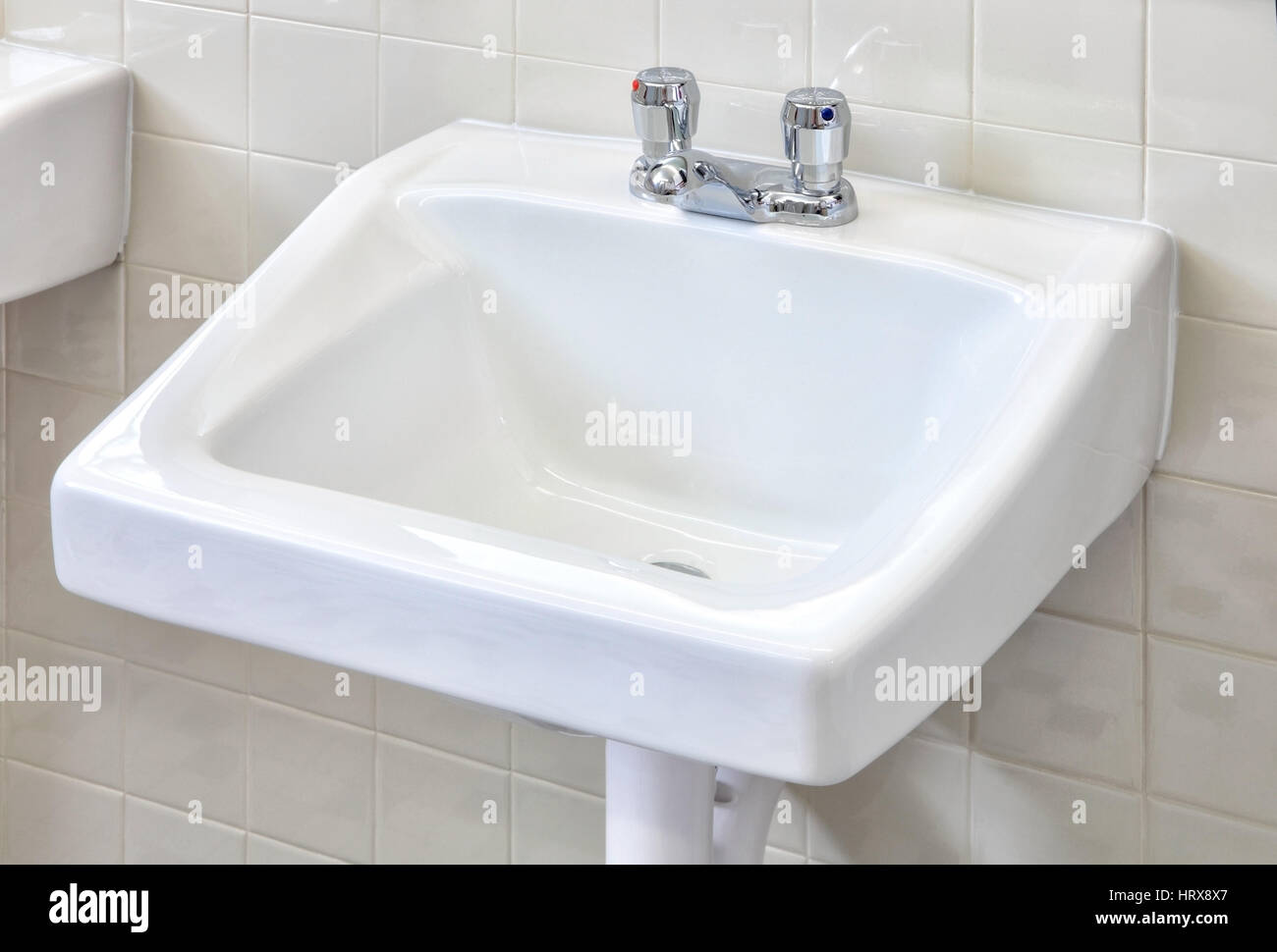 A water saving, conservation faucet installed on a wash basin in a public restroom. Stock Photo