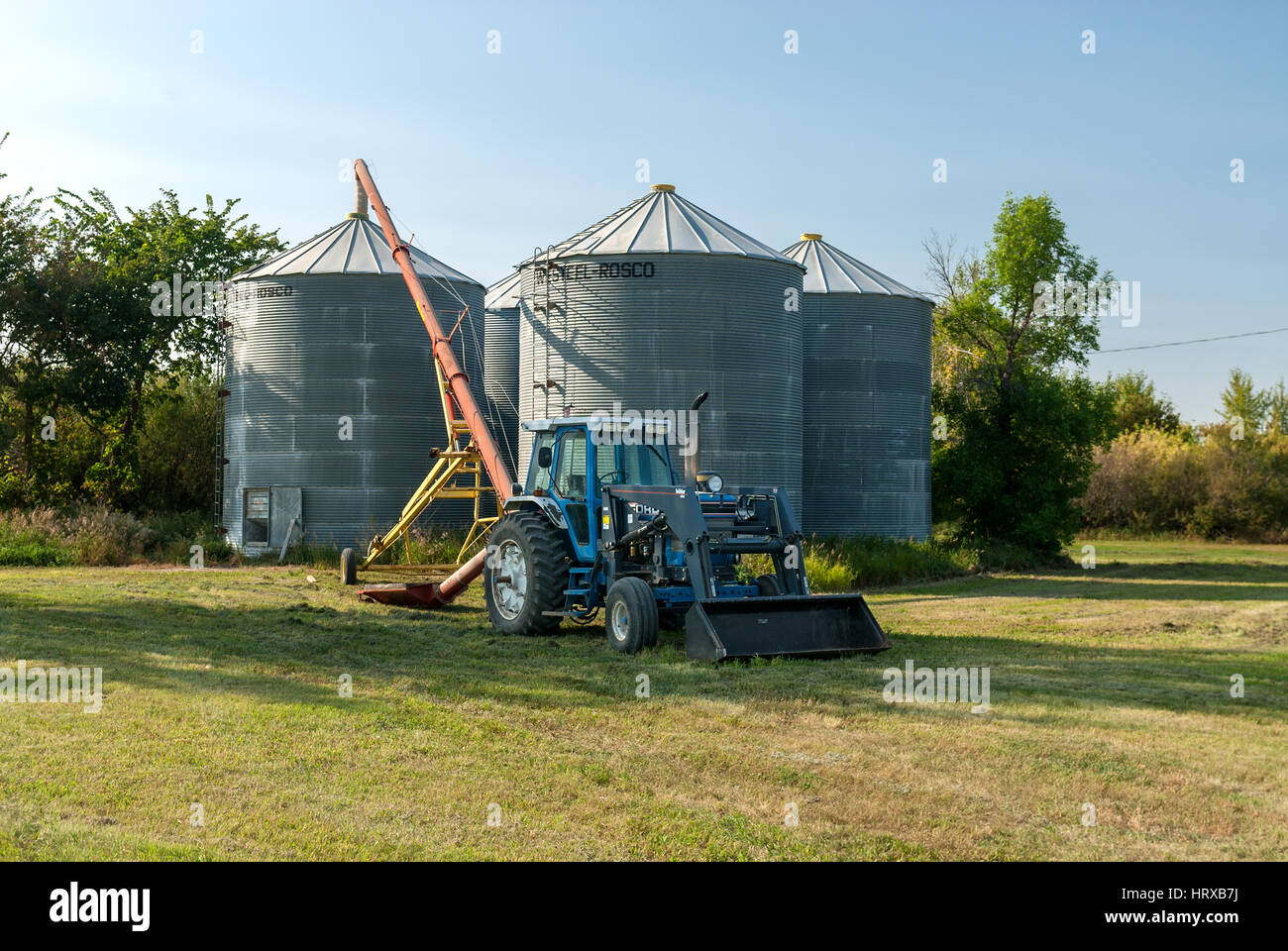 Farm tractor and silos Stock Photo