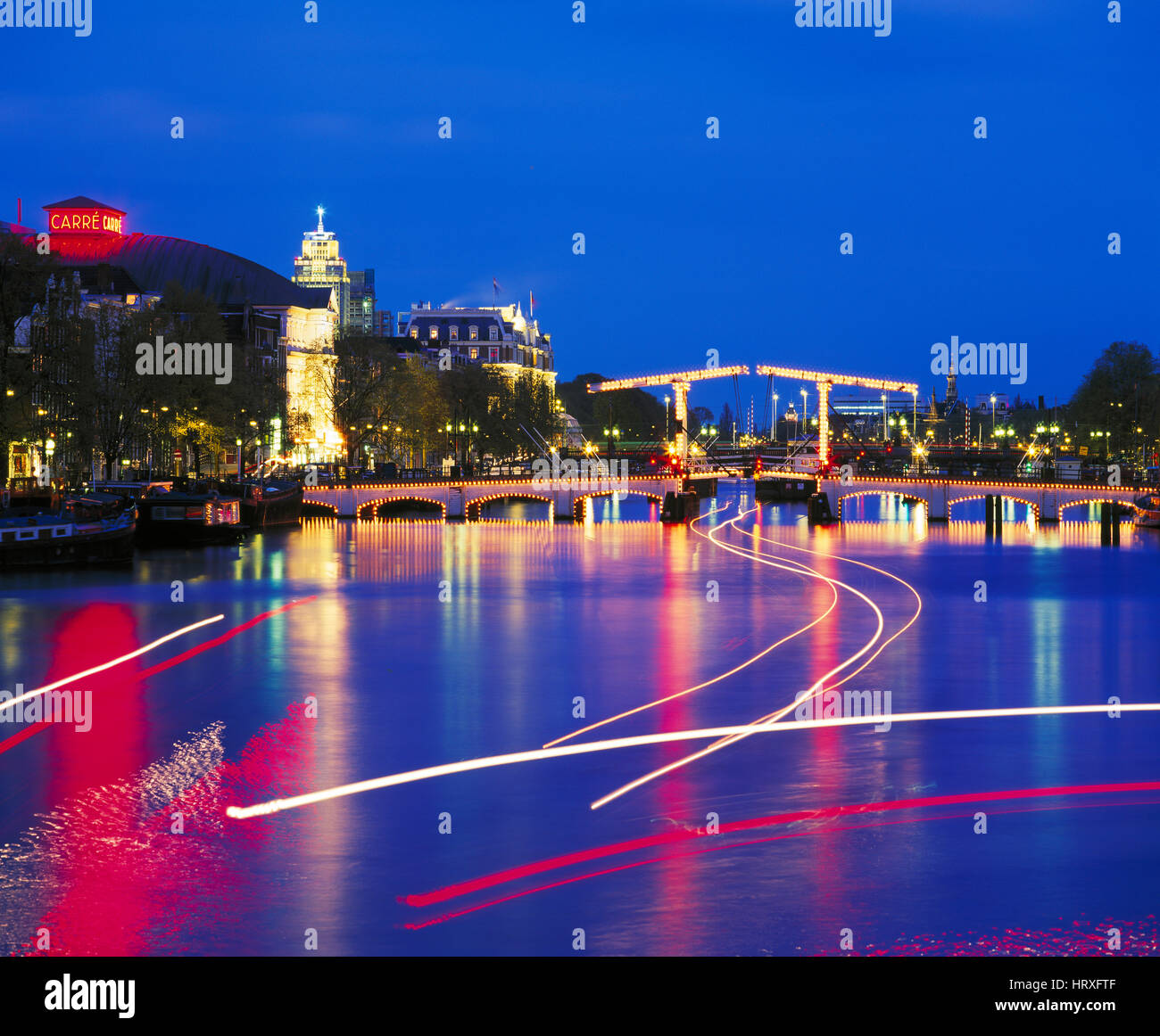 Skinny Bridge (Magere Brug) reflecting in the River Amstel at night, Amsterdam, Holland, Netherlands Stock Photo