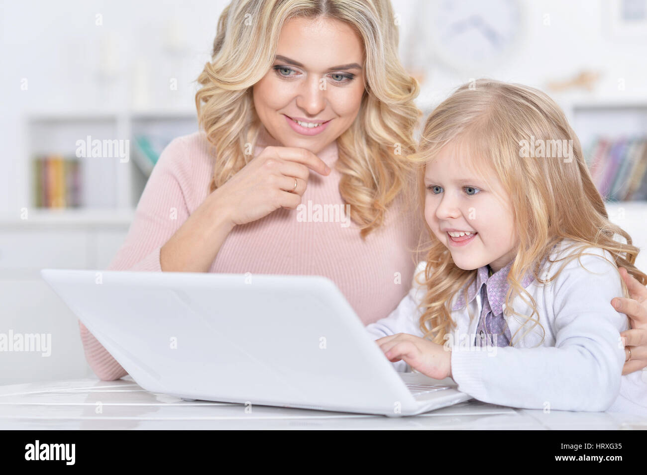 young woman and little girl using laptop Stock Photo - Alamy