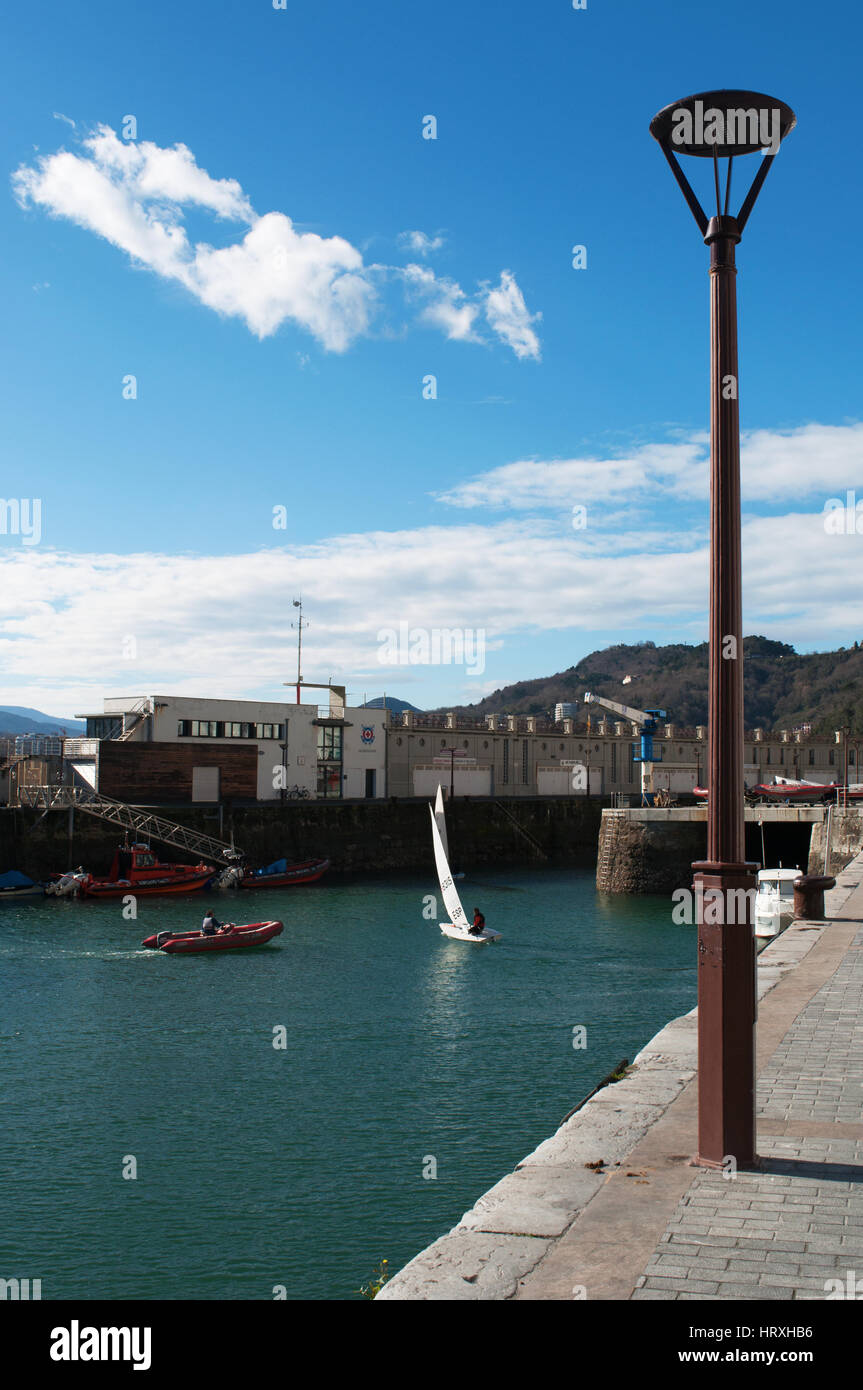 A sailboat in the port with view of the skyline of the Old City on the seafront of Donostia San