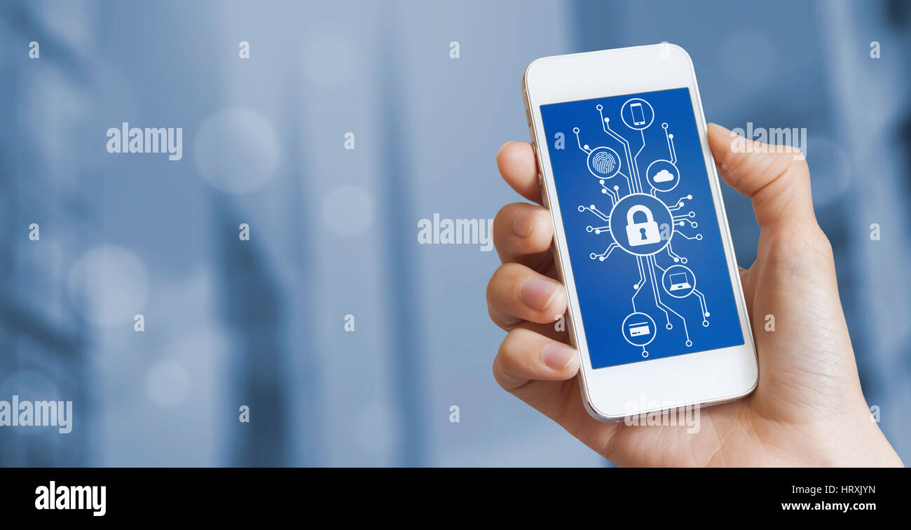 Cybersecurity concept with a person showing smartphone screen with cyber security icons in the shape of a electronic microchip circuit board and blurr Stock Photo
